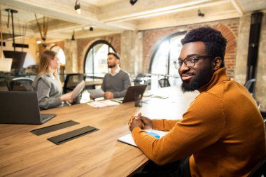 Ofiste. Ofiste bir grup genç proje detaylarını tartışıyor ve olaya dahil oluyor.