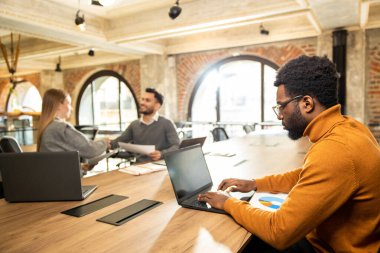 Yoğun bir gün. Ofiste çalışan ve olaya dahil olmuş ve konsantre olmuş genç profesyoneller.