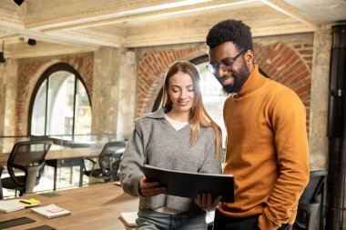 Yoğun bir gün. Ofiste çalışan ve olaya dahil olmuş ve konsantre olmuş genç profesyoneller.