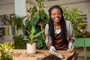 Çiçekçi iş başında. Çiçekçide çiçekçiyle çalışan genç bir bayan çiçekçi.