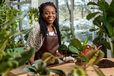 Çiçek ekme. Gülümseyen genç bir kadın. Rasta kaplamalı çiçekler ve ilgili görünüyor.