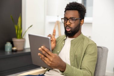 Bir çağrı üzerine. Zeytin gömlekli genç adam iş görüşmesi yaparken ciddi görünüyor.