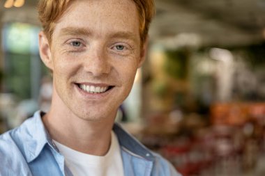 Mutlu genç adam. Gülümseyen mavi gömlekli genç adam mutlu ve mutlu görünüyor.