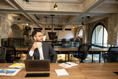 İşte sabah. Genç beyaz adam ofiste oturuyor ve kahve içiyor.