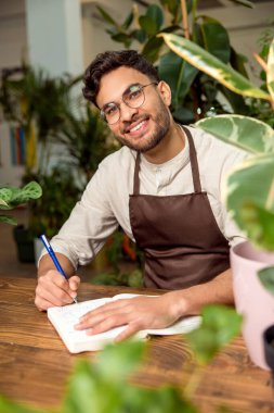 Çevrimiçi emir. Çiçekçi asistanı online siparişleri analiz ediyor ve memnun görünüyor