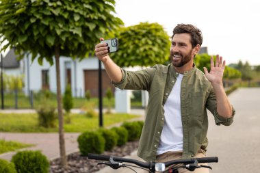 Görüntülü arama. Sakallı genç adam bir video görüşmesi yapıyor ve pozitif görünüyor.