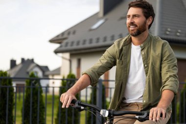 Kendinden emin genç adam. Bisikletli beyaz sakallı genç adam kendinden emin görünüyor.