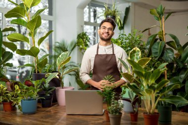 Çiçekçi. Çiçekçide çalışan erkek tezgahtar kendini güvende hissediyor.