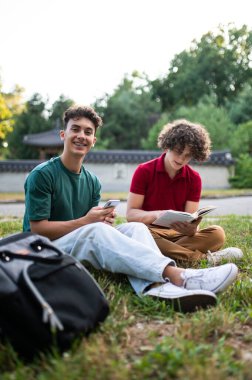 Parktaki gençler. Parktaki çimlerde oturan ve birlikte vakit geçiren gençler.