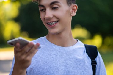 Sesli mesaj. Sesli mesaj kaydeden ve gülümseyen bir gencin belini kaldırın.