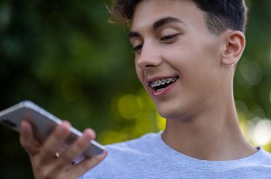 Sesli mesaj. Sesli mesaj kaydeden ve gülümseyen bir gencin belini kaldırın.