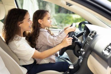 Otantik bir an. Genç bir kadın ve kızı arabada oturuyor ve neşeli görünüyorlar.