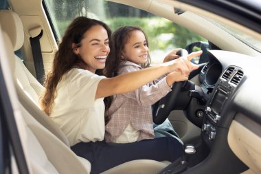 Otantik bir an. Genç bir kadın ve kızı arabada oturuyor ve neşeli görünüyorlar.