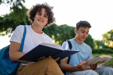 Derslere hazırlanıyorum. Parkta oturup birlikte ders çalışan iki genç.