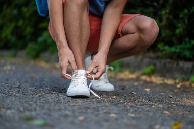 Snickers 'ı bağlıyorum. Parkta terliklerini bağlayan bir adama yaklaş.