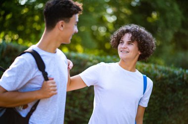 Gençler. İki genç birlikte vakit geçiriyorlar ve telefonda bir şeyler izliyorlar.