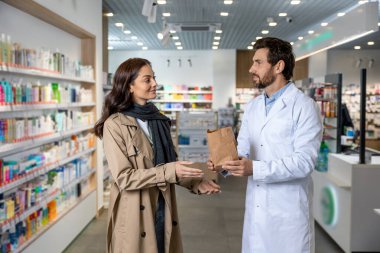 Eczacıyla konuşuyorum. Koyu saçlı, genç ve güzel bir kadın eczacıyla konuşuyor ve ilgileniyormuş gibi görünüyor.