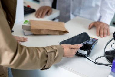 Ödeme kartıyla. Eczanede ilaçların parasını maaş kartıyla ödeyen kadın müşteri