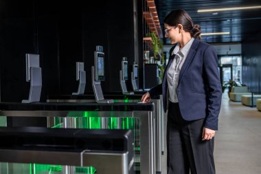 Güvenlik kontrolü. Ofisteki kadın giriş kartını kullanarak güvenlik noktasından geçiyor.