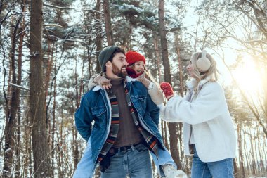 Kış ormanı Genç bir aile, kış ormanlarında birlikte vakit geçirir.