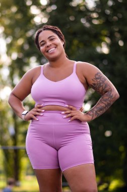 Mutlu kadın. Pembe elbiseli, kendinden emin Afro-Amerikan kadın mutlu görünüyor.