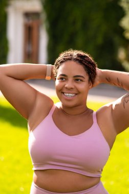 Sabah esnemesi. Pembe spor kıyafetli kadın esneme hareketleri yapıyor ve rahatlamış görünüyor.