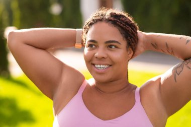 Sabah esnemesi. Pembe spor kıyafetli kadın esneme hareketleri yapıyor ve rahatlamış görünüyor.