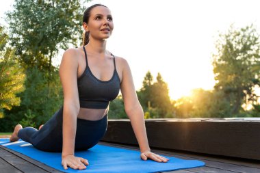 Yoga. Yoga minderinde yukarı bakan köpek pozunda genç bir kadın.