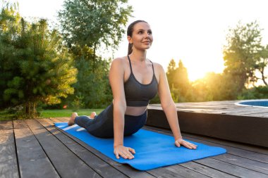 Yoga. Yoga minderinde yukarı bakan köpek pozunda genç bir kadın.