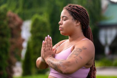 Yoga yapıyordum. Pembeli uzun saçlı kadın dışarıda yoga yapıyor ve sakin görünüyor.