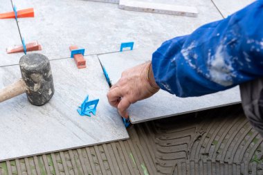 Tuğlacı tiler yeni bir zemin için çimento yapıştırıcısına fayanslar yerleştirir. İnşaat endüstrisi. İnşa ediliyor.