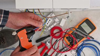 Kablo sökücü kerpetenle çalışan elektrik işçisi elektrik sisteminin kablolarını hazırlıyor. İnşaat endüstrisi. Görüntü.