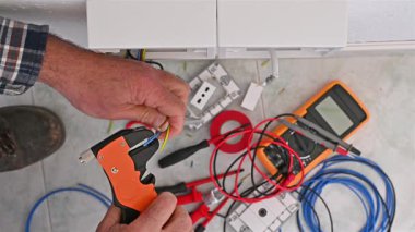 Kablo sökücü kerpetenle çalışan elektrik işçisi elektrik sisteminin kablolarını hazırlıyor. İnşaat endüstrisi. Görüntü.
