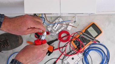 Kablo kesici penseyle çalışan elektrik işçisi elektrik sisteminin elektrik kablolarını hazırlıyor. İnşaat endüstrisi. Görüntü.
