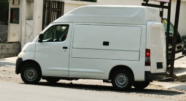 Şehir caddesinde küçük beyaz bir minibüs. nakliye kavramı.