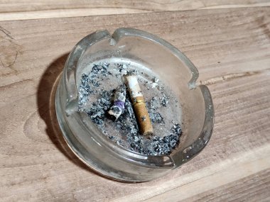 ahşap masa üzerinde kül tablası ile sigara.