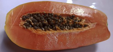 Beyaz arka planda taze kırmızı ve siyah papaya.