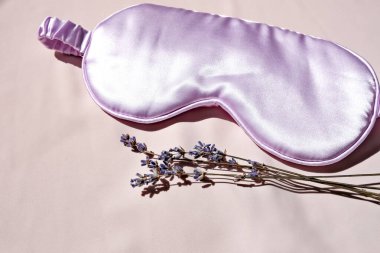 Yatağında doğal lavanta olan uyku maskesi. Yan görünüm, metin için boşluk.