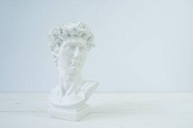 Beyaz arka planda David 'in kafasının alçıdan büstü. Yan görünüm, metin için boşluk.