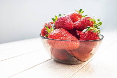 Cam kasede taze çilekler, arka planda yakın plan. Mesaj için yer. Yan görünüm.