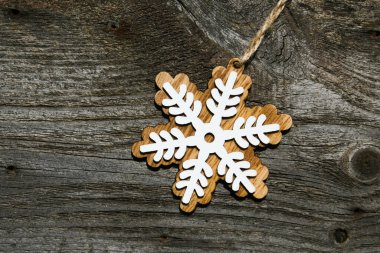 Tahta arka planda kar tanesi şeklinde bir Noel süsü. Üst görünüm, metin için yer.