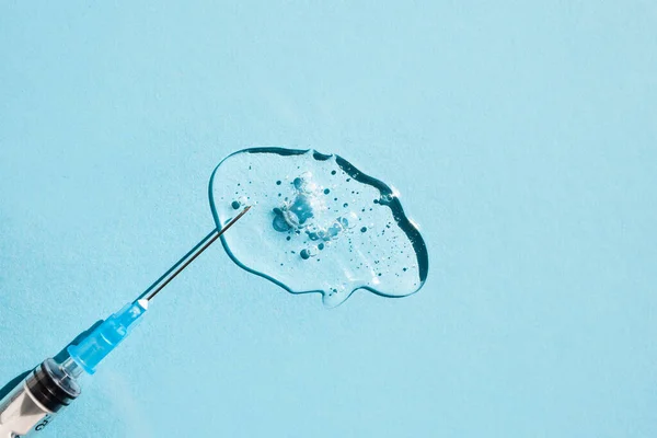 Jednorázová Injekční Stříkačka Průhlednou Gelovitou Tekutinou Modrém Pozadí Boční Pohled — Stock fotografie