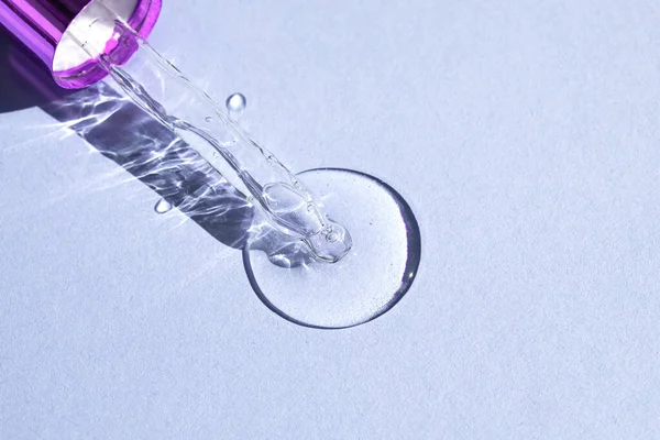 带有气泡的玻璃管 在紫罗兰背景上滴滴透明的润肤乳液 顶部视图 文字位置 — 图库照片