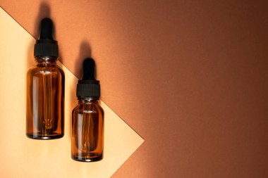 Bej arka planda cam damlatan şişeler gölgeler oluşturur. Üst görünüm, metin için yer.