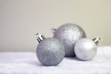 Noel arkaplanı. Gri arka planda gümüş renkli Noel topları. Metin için boşluk, kenar görünüm.