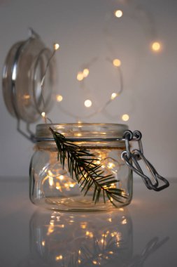İçinde lambalar olan cam kavanoz. Yeni yıl ve Noel kavramı. Dikey resim.