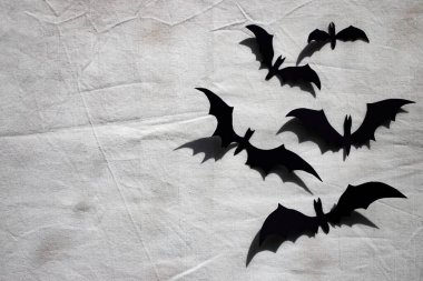 Cadılar Bayramı için arka plan. Kirli bir çarşafta kağıt yarasalar. Düz yatış, metin için yer.