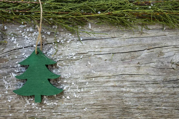 Christmas background. Natural wood texture with spruce branch and toy wooden tree. Space for text,top view.