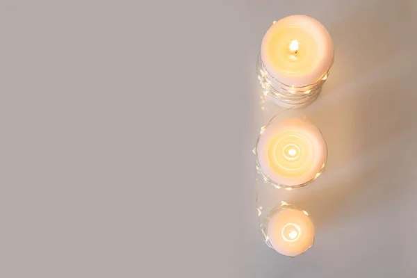 Drei Große Brennende Kerzen Und Ein Weihnachtskranz Vor Hellem Hintergrund — Stockfoto