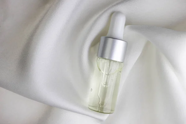 Glassflaske Med Kosmetisk Væske Hvit Silke Toppsikt Nærbilde – stockfoto